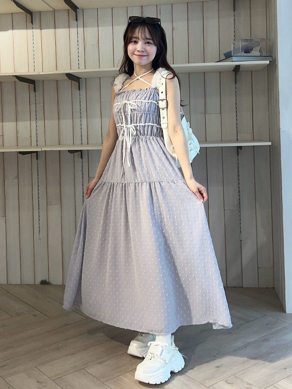 ホワイト系のショルダーバッグ、ブルー系のワンピース、ホワイト系のシューズを着用したレディースの春コーディネートの2枚目の写真