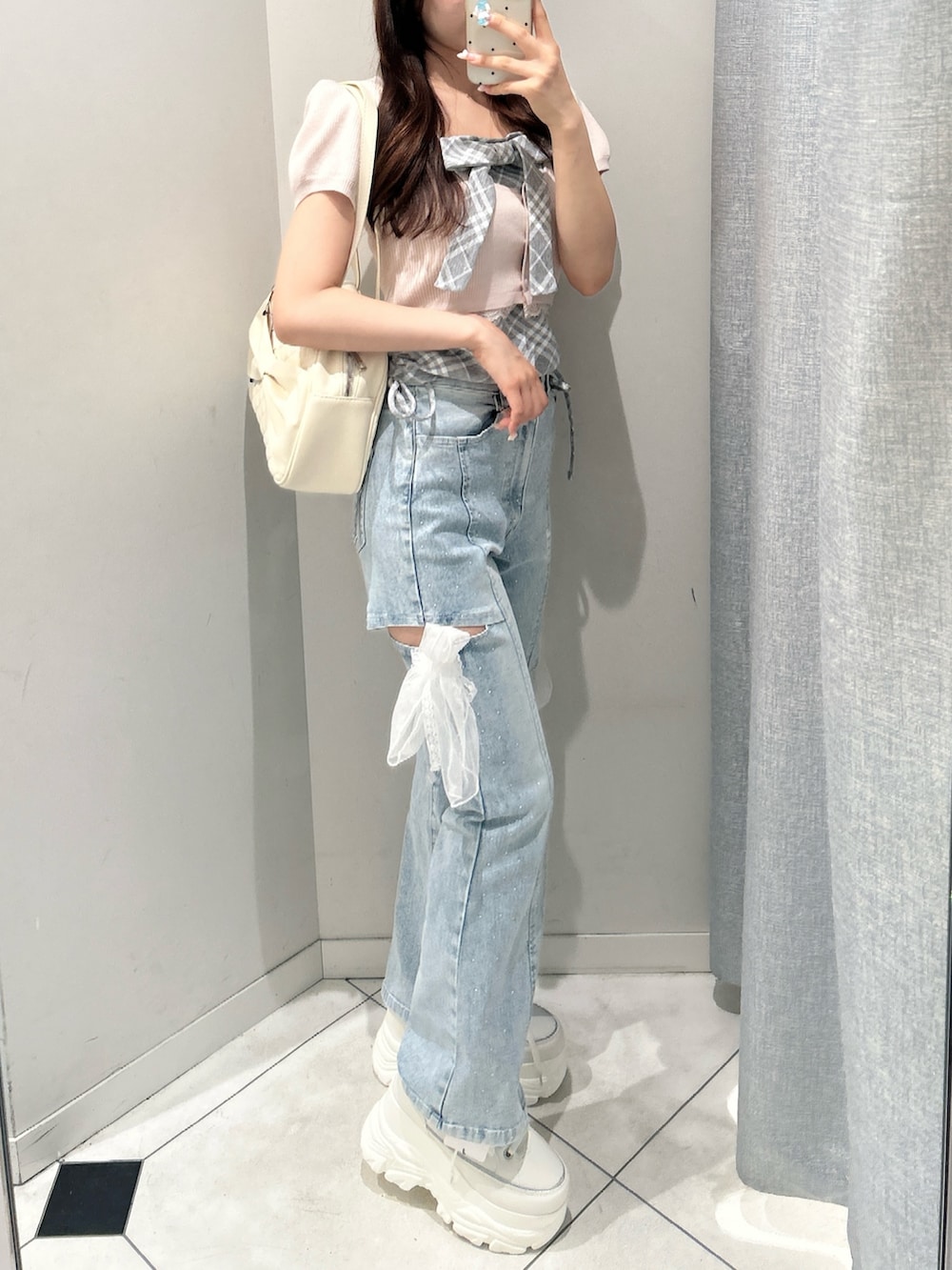 ブルー系のデニムパンツ、ピンク系のワンピース、ホワイト系のスニーカーを着用したレディースの夏コーディネートの3枚目の写真