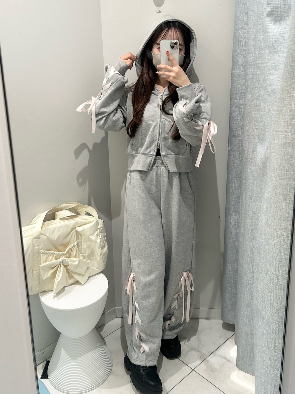 グレー系のスウェットパンツ、グレー系のパーカー、イエロー系のボストンバッグを着用したレディースの冬コーディネートの2枚目の写真