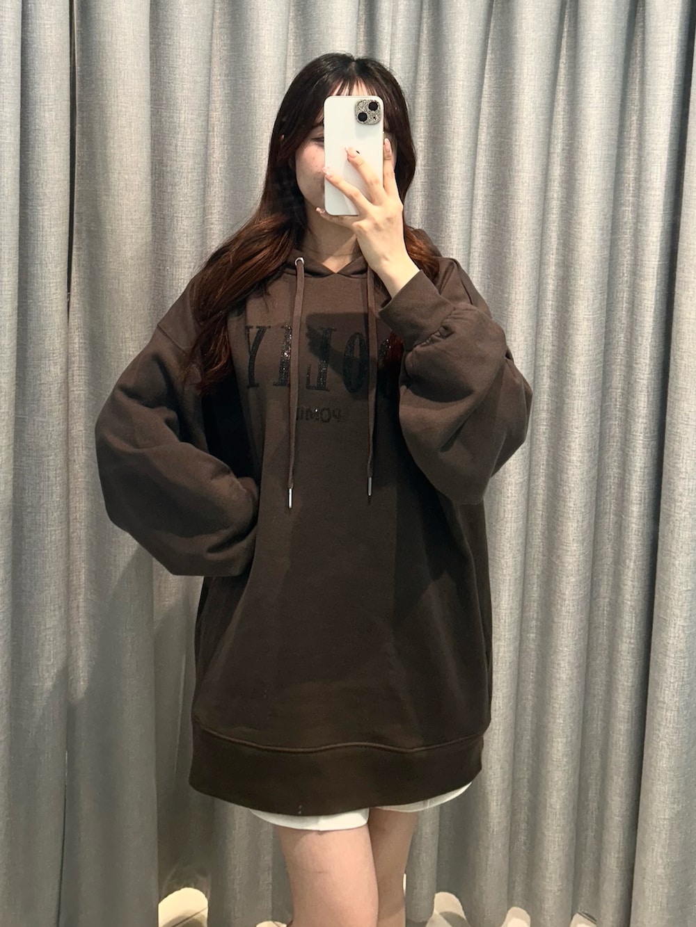 ブラック系のパーカー、ホワイト系のスカートを着用したレディースの秋コーディネートの5枚目の写真