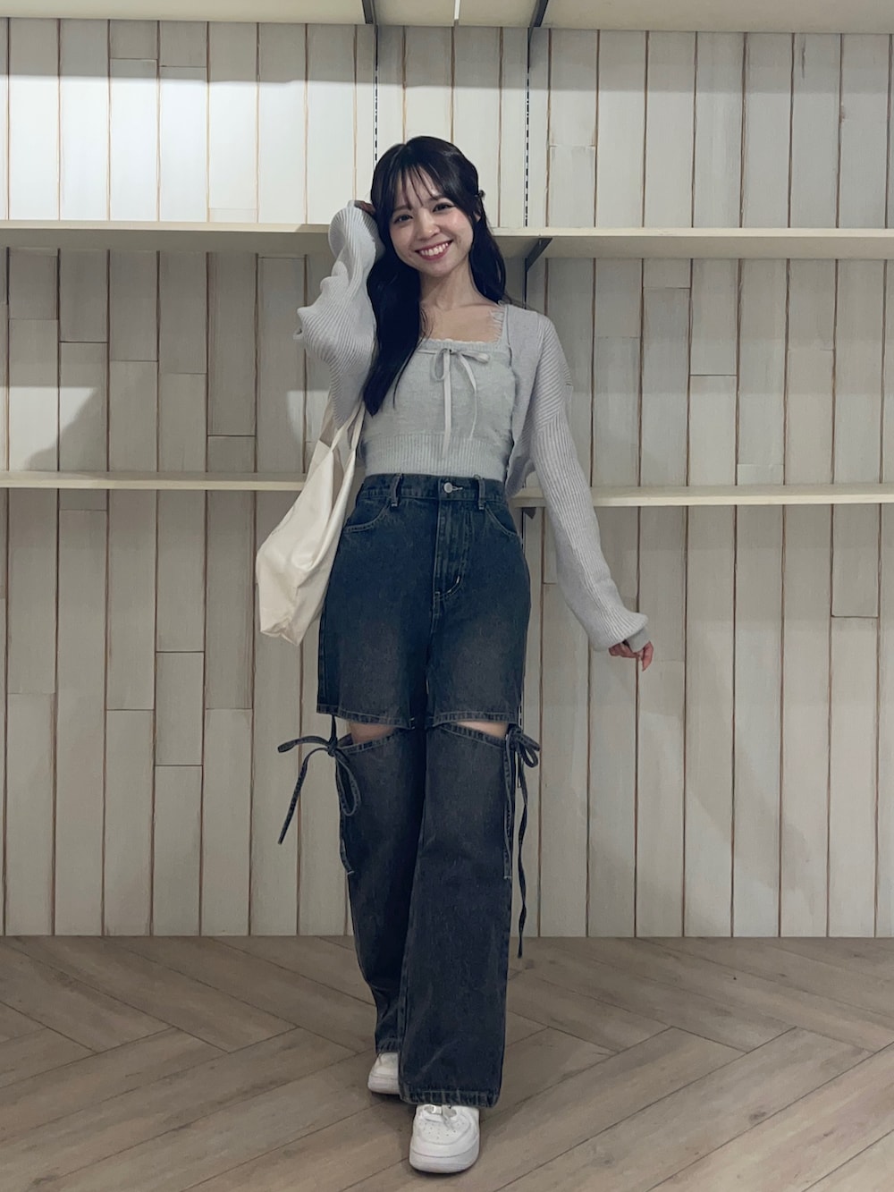 ブルー系のアンサンブル、ブラック系のデニムパンツ、シルバー系のショルダーバッグを着用したレディースの秋コーディネートの4枚目の写真