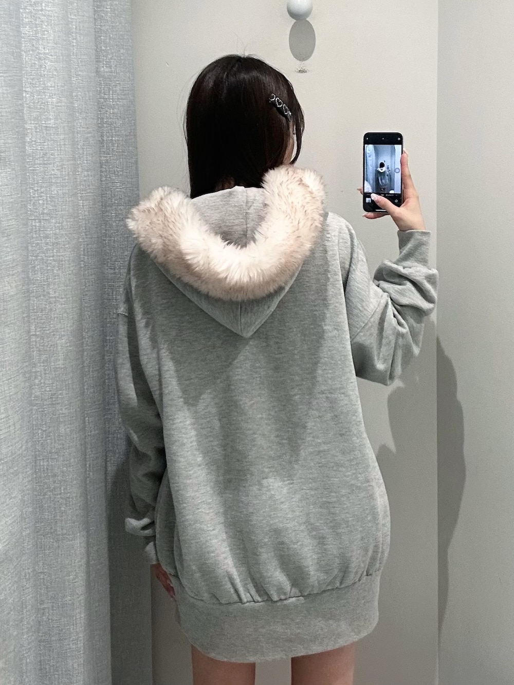 グレー系のパーカー、ホワイト系のスカートを着用したレディースの秋コーディネートの5枚目の写真