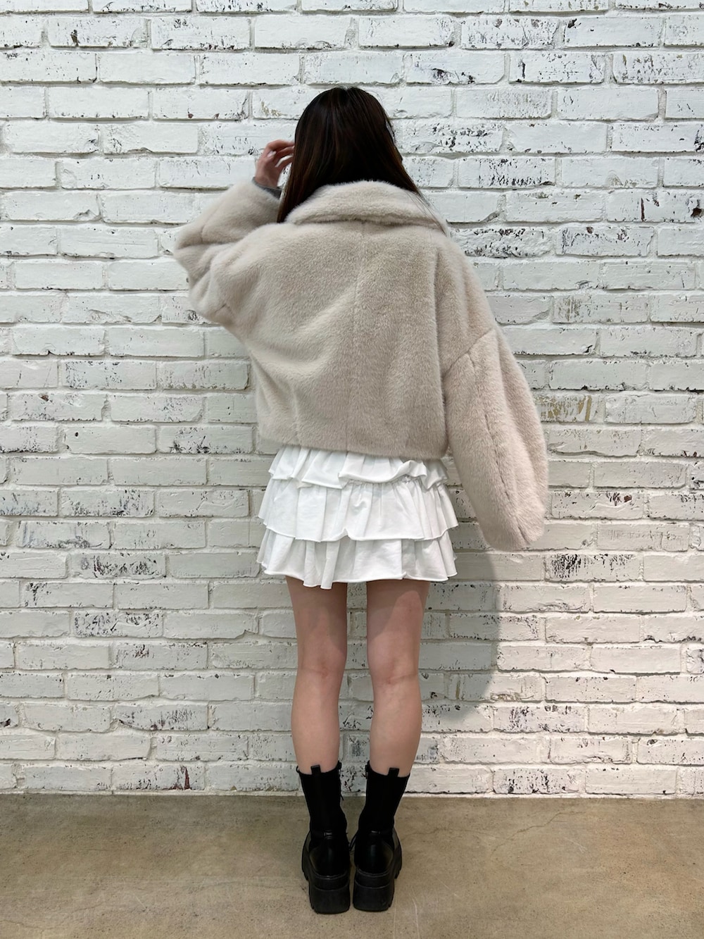 ベージュ系のブルゾン、ホワイト系のスカート、ブラック系のブーツを着用したレディースの秋コーディネートの2枚目の写真