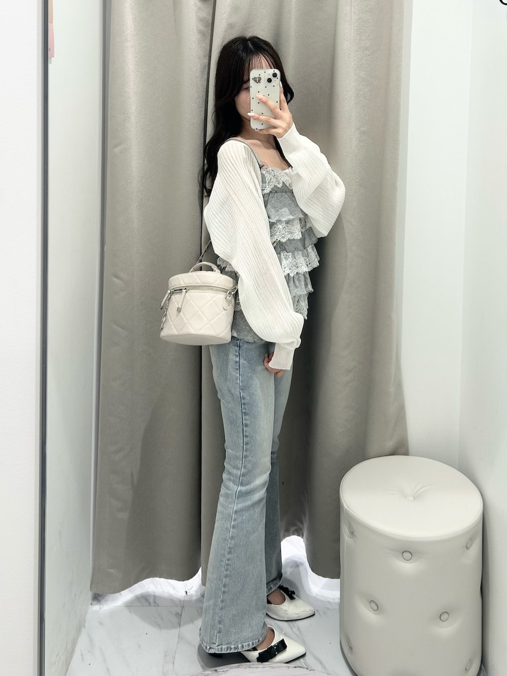 ブルー系のデニムパンツ、ホワイト系のドレスシューズ、ホワイト系のショルダーバッグを着用したレディースの春コーディネートの2枚目の写真