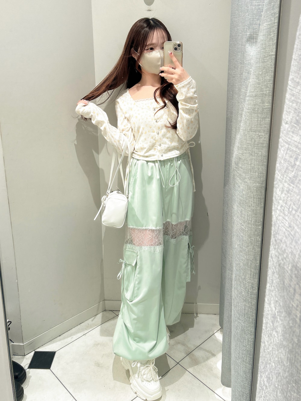 ホワイト系のスニーカー、グリーン系のカーゴパンツ、ホワイト系のトートバッグを着用したレディースの冬コーディネートの5枚目の写真