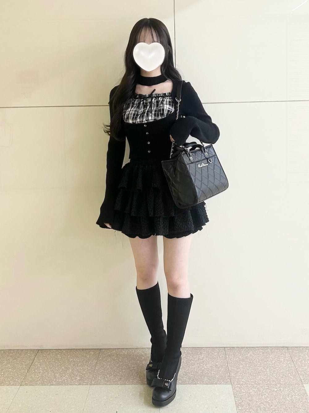 ブラック系のスカート、ブラック系のトートバッグ、ブラック系のブーツを着用したレディースの春コーディネートの6枚目の写真