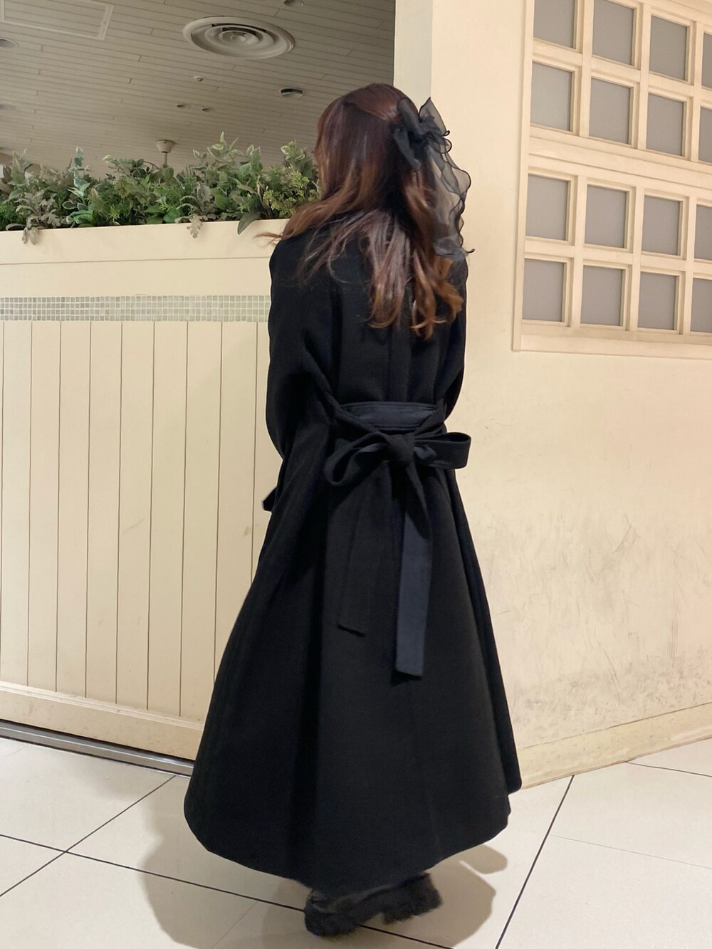 ブラック系のステンカラーコート、ブラック系のローファー、ブラック系のワンピースを着用したレディースの秋コーディネートの4枚目の写真