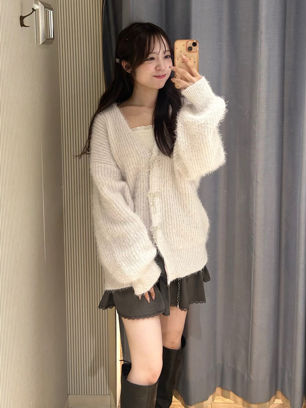 パープル系のカーディガン/ボレロ、ホワイト系のキャミソール、グレー系のスカートを着用したレディースの秋コーディネートの2枚目の写真