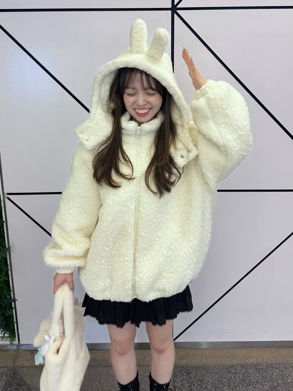 ホワイト系のジャケット/アウター、ホワイト系のバッグ、ブラック系のスカートを着用したレディースの冬コーディネートの4枚目の写真