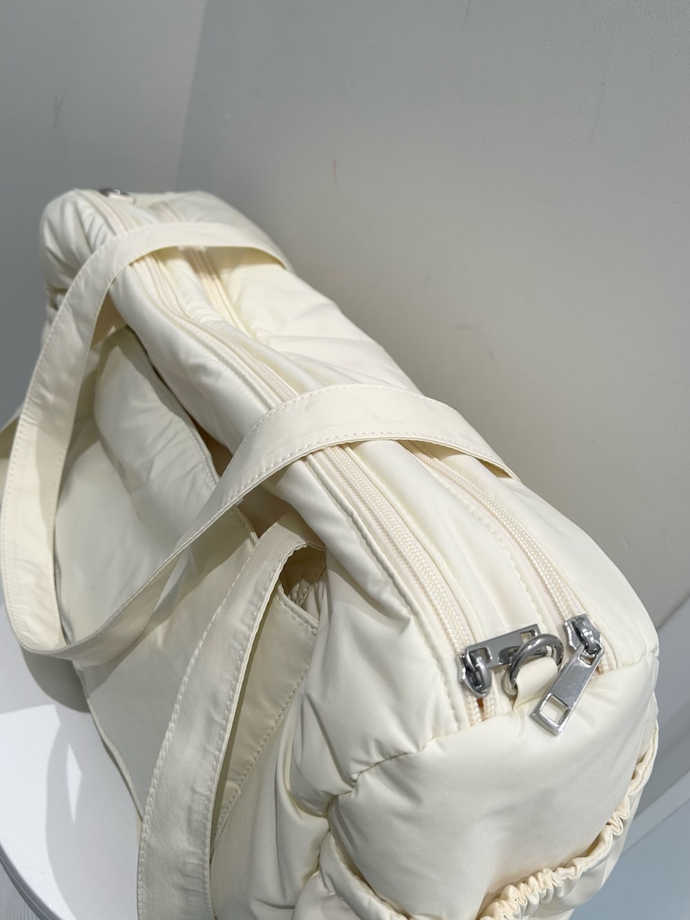 グレー系のスウェットパンツ、グレー系のパーカー、イエロー系のボストンバッグを着用したレディースの冬コーディネートの9枚目の写真