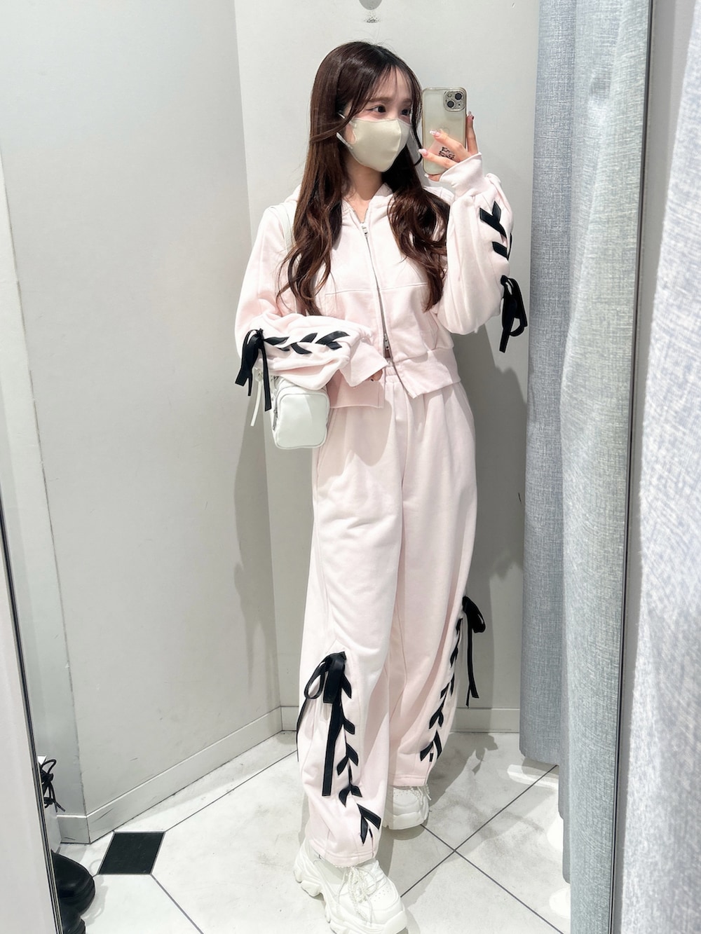 ホワイト系のスニーカー、ピンク系のスウェットパンツ、ピンク系のパーカーを着用したレディースの冬コーディネートの9枚目の写真