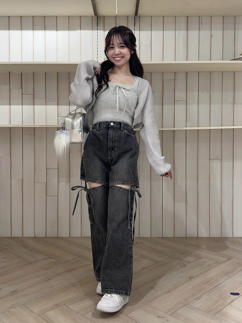 ブルー系のアンサンブル、ブラック系のデニムパンツ、シルバー系のショルダーバッグを着用したレディースの秋コーディネートの2枚目の写真