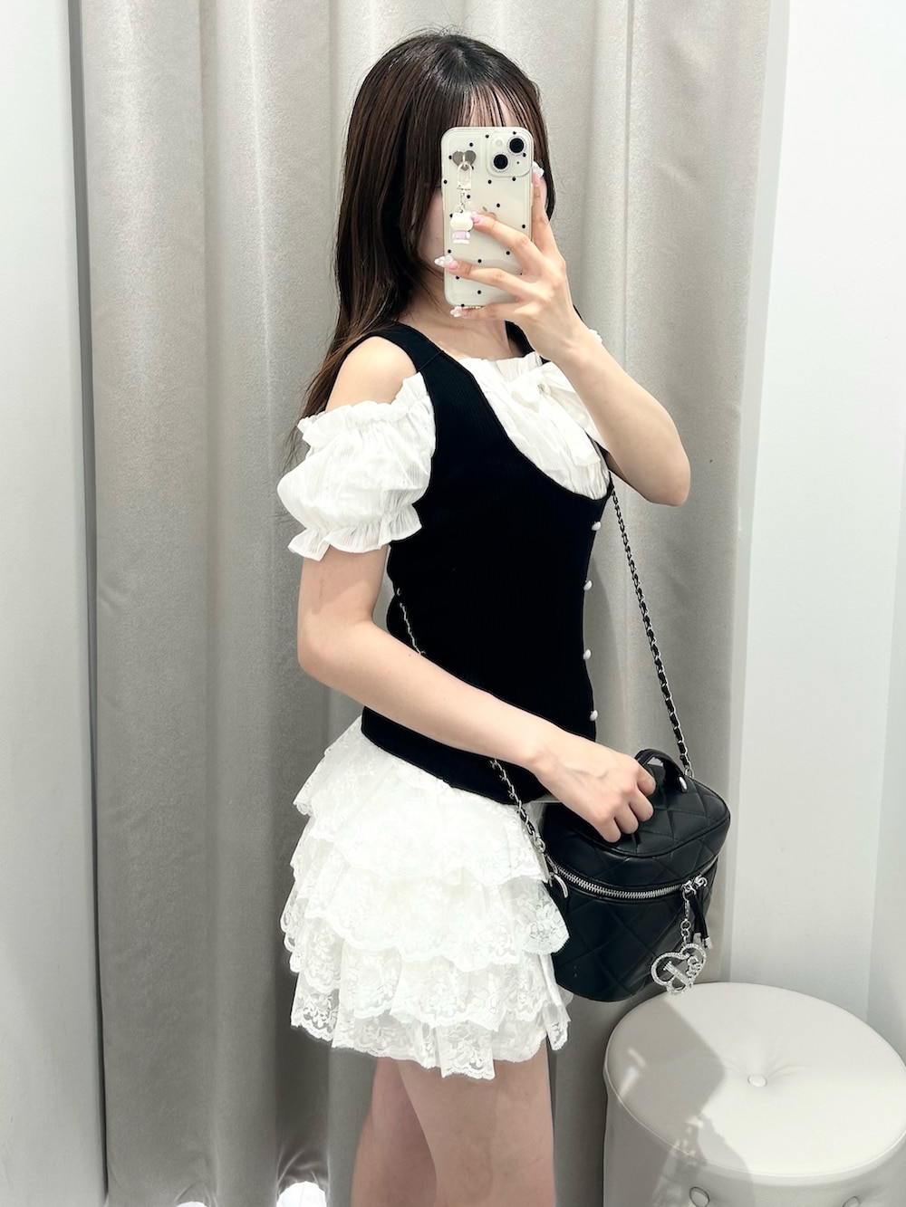ブラック系のニット/セーター、ホワイト系のスカート、ブラック系のショルダーバッグを着用したレディースの夏コーディネートの5枚目の写真