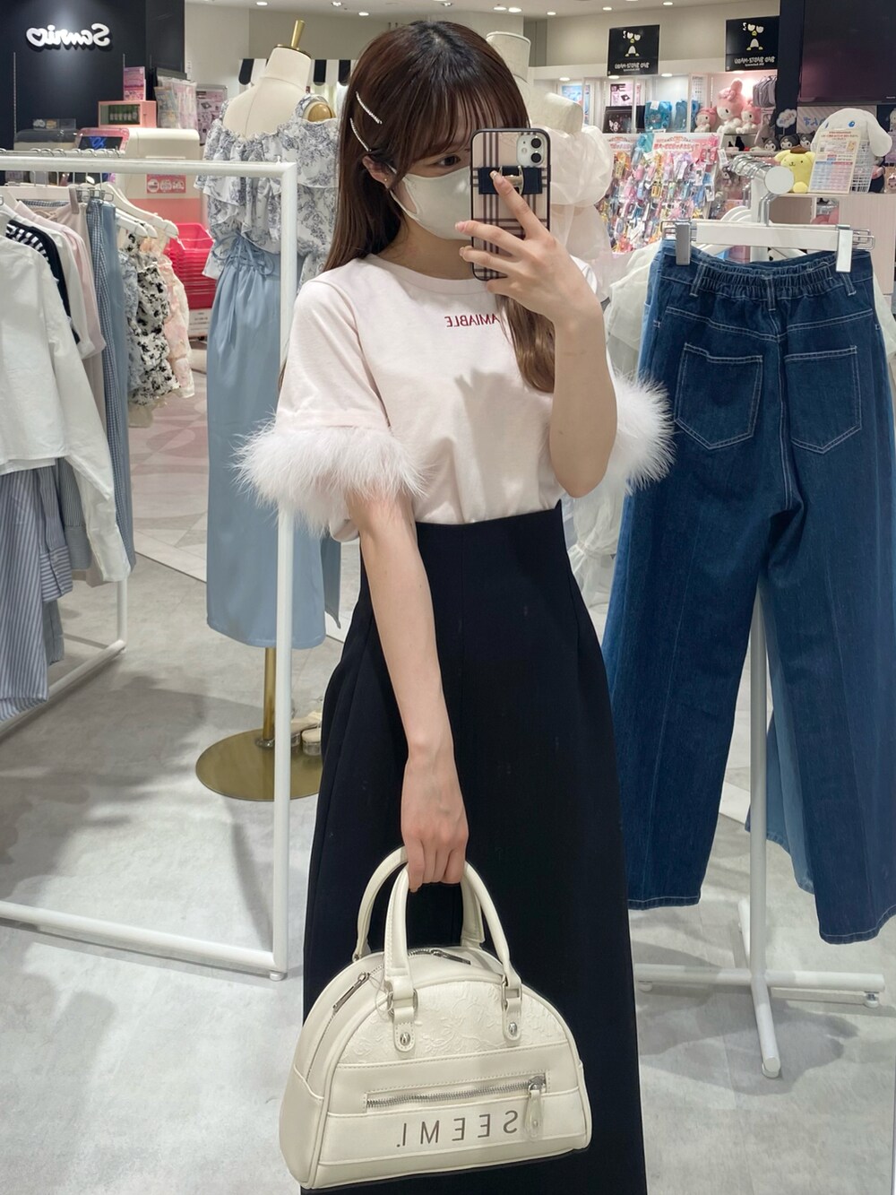 ピンク系のTシャツ/カットソー、ブラック系のスカート、ホワイト系のボストンバッグを着用したレディースの春コーディネートの3枚目の写真