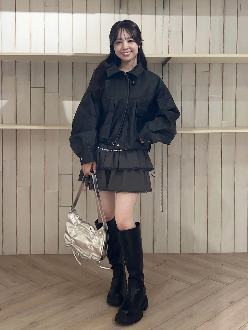 ブラック系のブルゾン、グレー系のスカート、ブラック系のブーツを着用したレディースの秋コーディネートの4枚目の写真