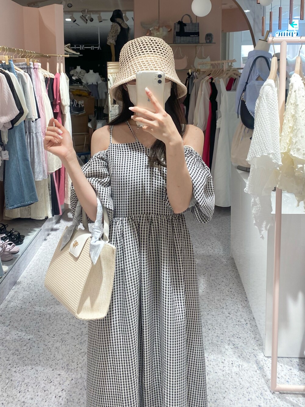 ホワイト系のショルダーバッグ、ホワイト系のスニーカー、ブラック系のワンピースを着用したレディースの夏コーディネートの3枚目の写真