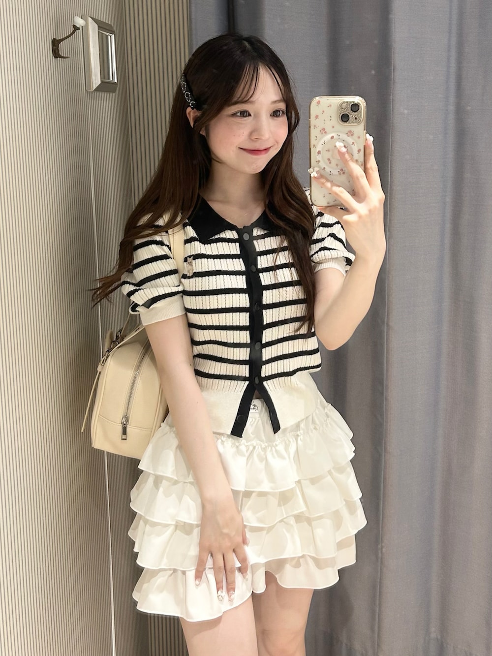 その他のポロシャツ、ホワイト系のスカート、ホワイト系のショルダーバッグを着用したレディースの夏コーディネートの2枚目の写真