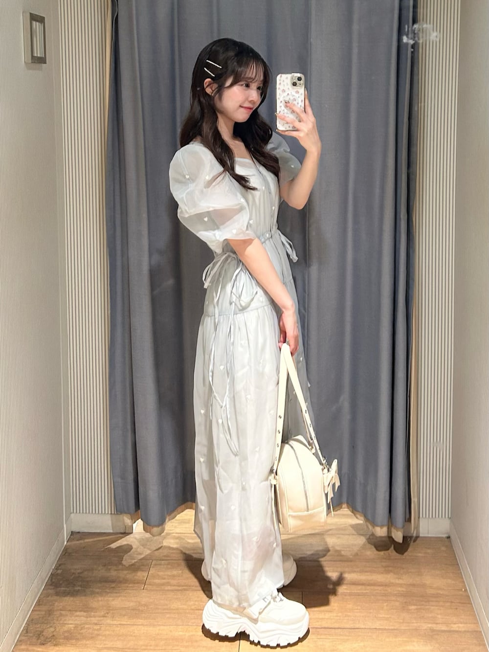 ブルー系のワンピース、ホワイト系のショルダーバッグ、ピンク系のシューズを着用したレディースの春コーディネートの2枚目の写真