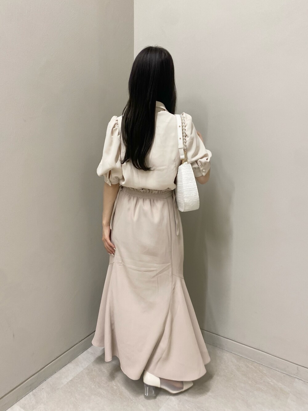 ホワイト系のショルダーバッグ、ベージュ系のシャツ/ブラウス、ベージュ系のスカートを着用したレディースの夏コーディネートの3枚目の写真