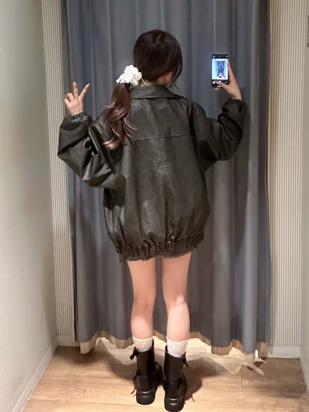 ホワイト系のキャミソール、ブラック系のブルゾン、グレー系のスカートを着用したレディースの秋コーディネートの4枚目の写真