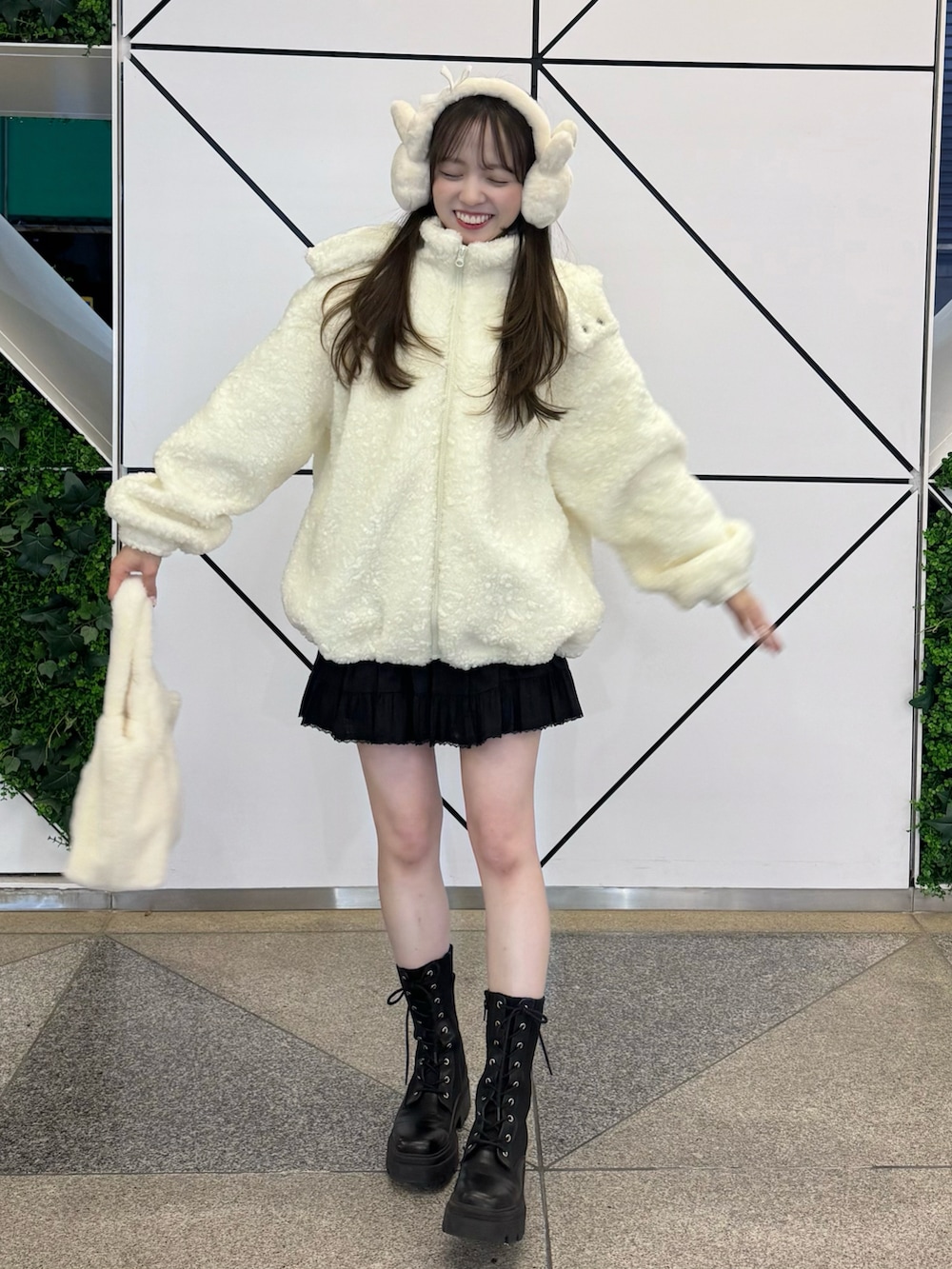 ホワイト系のジャケット/アウター、ホワイト系のバッグ、ブラック系のスカートを着用したレディースの冬コーディネートの2枚目の写真