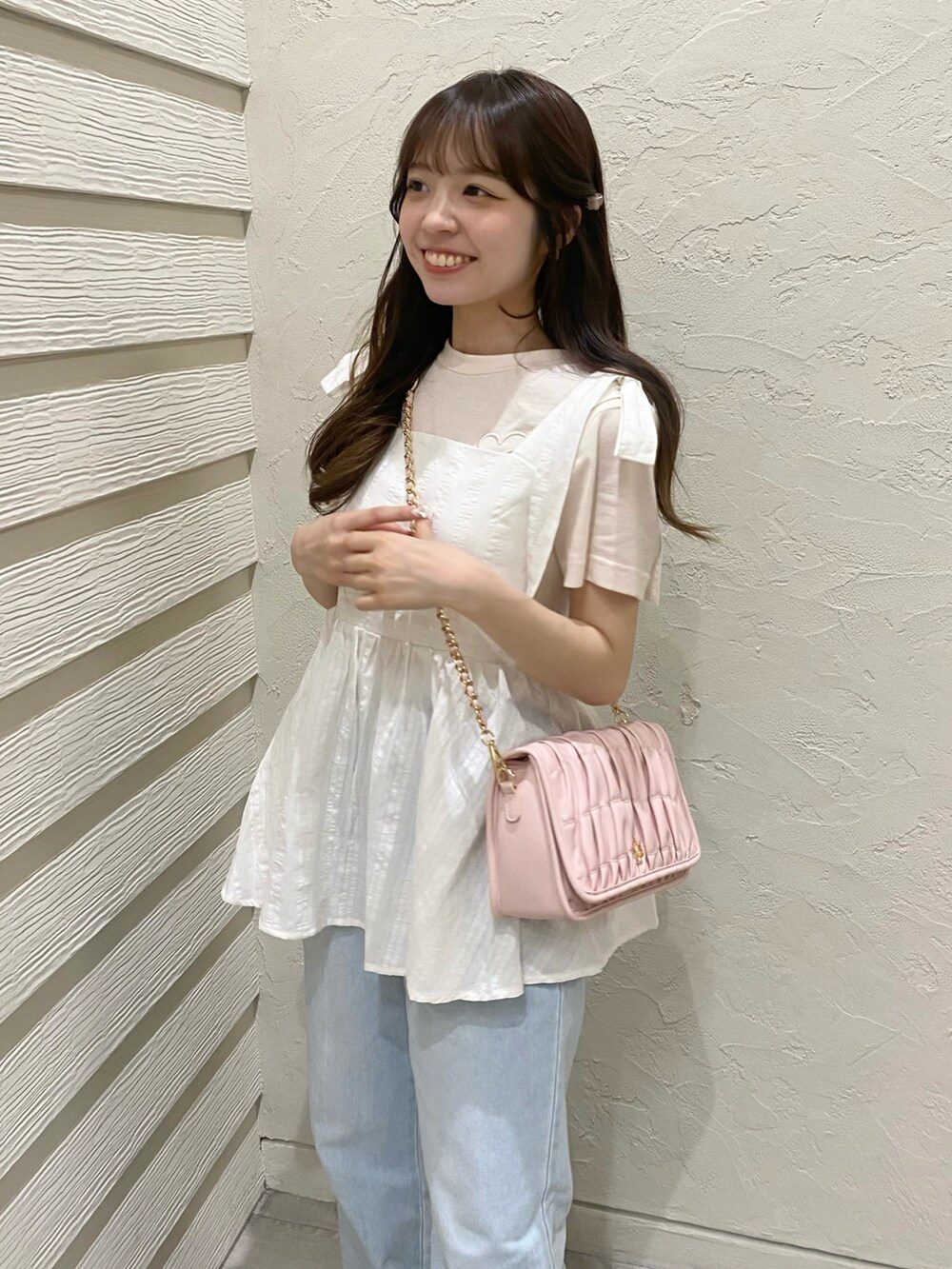 ホワイト系のスニーカー、ピンク系のショルダーバッグ、ホワイト系のTシャツ/カットソーを着用したレディースの夏コーディネートの2枚目の写真