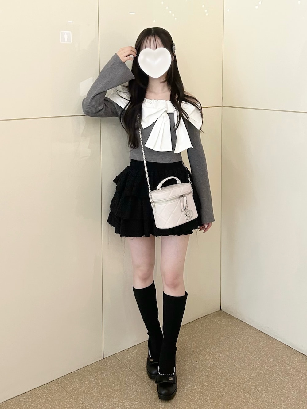 グレー系のニット/セーター、ホワイト系のショルダーバッグ、ブラック系のスカートを着用したレディースの冬コーディネートの7枚目の写真