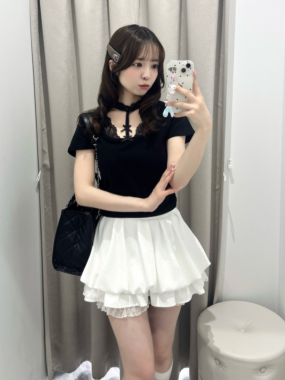 ブラック系のトートバッグ、ホワイト系のスカート、ブラック系のTシャツ/カットソーを着用したレディースの春コーディネートの3枚目の写真