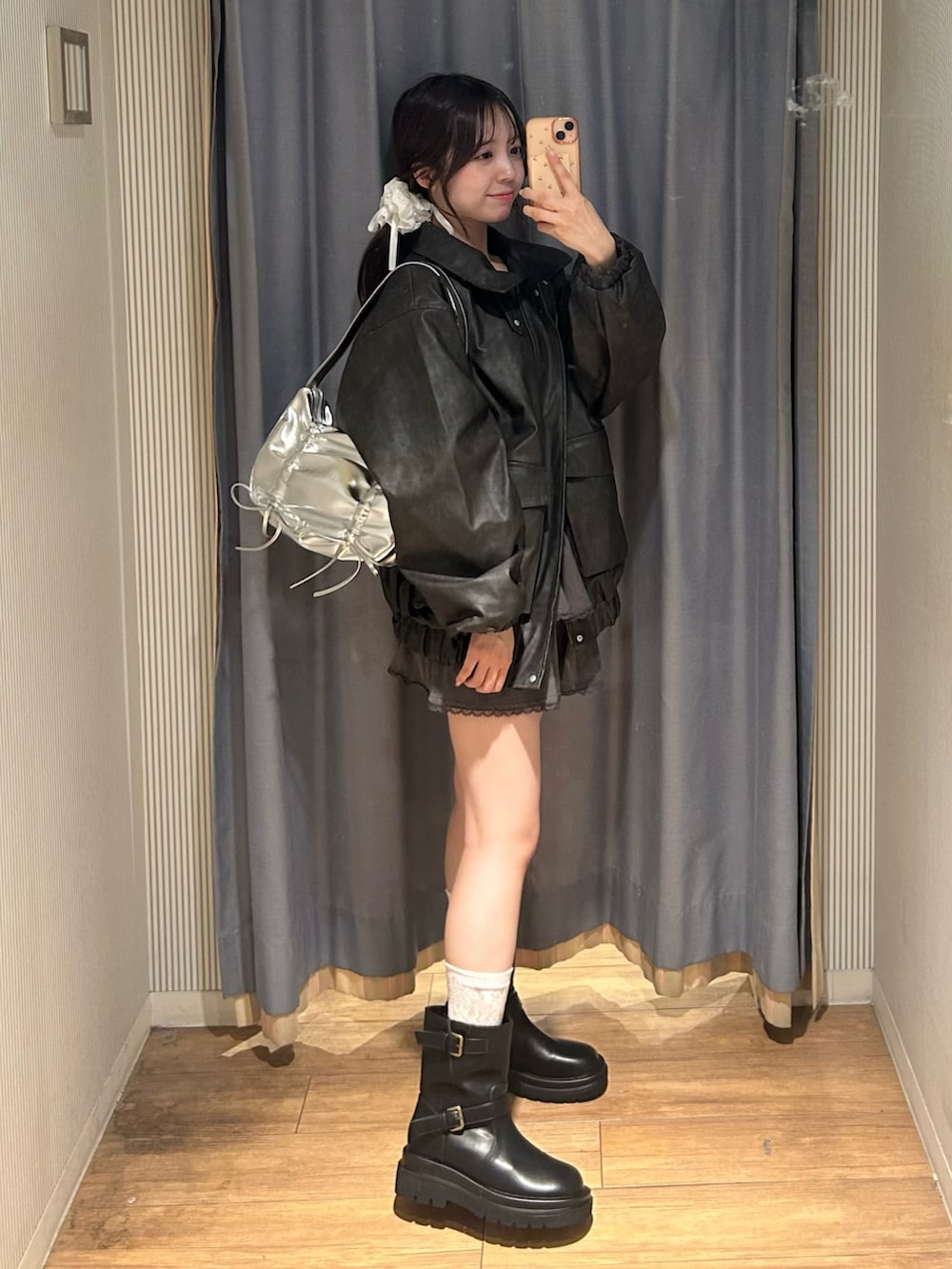 ホワイト系のキャミソール、ブラック系のブルゾン、グレー系のスカートを着用したレディースの秋コーディネートの5枚目の写真