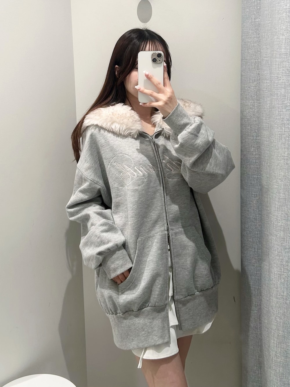 グレー系のパーカー、ホワイト系のスカートを着用したレディースの秋コーディネートの6枚目の写真