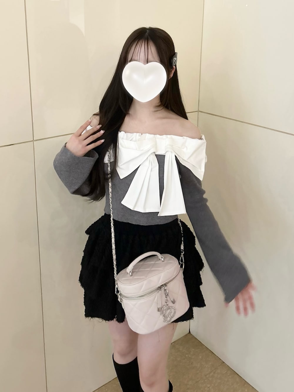 グレー系のニット/セーター、ホワイト系のショルダーバッグ、ブラック系のスカートを着用したレディースの冬コーディネートの4枚目の写真