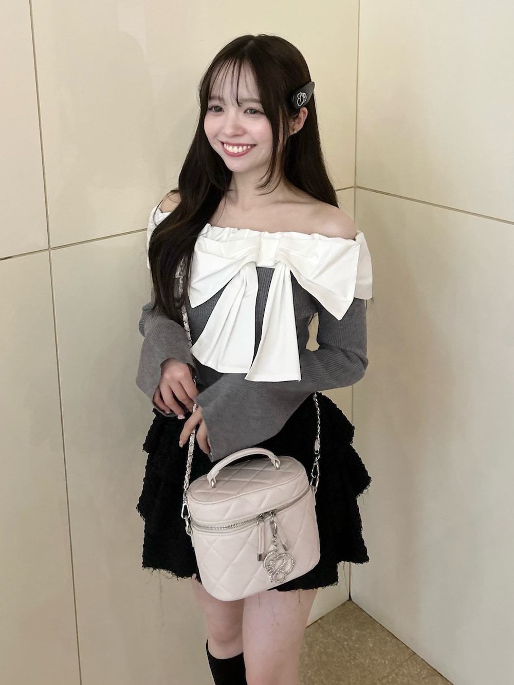 グレー系のニット/セーター、ホワイト系のショルダーバッグ、ブラック系のスカートを着用したレディースの冬コーディネートの5枚目の写真