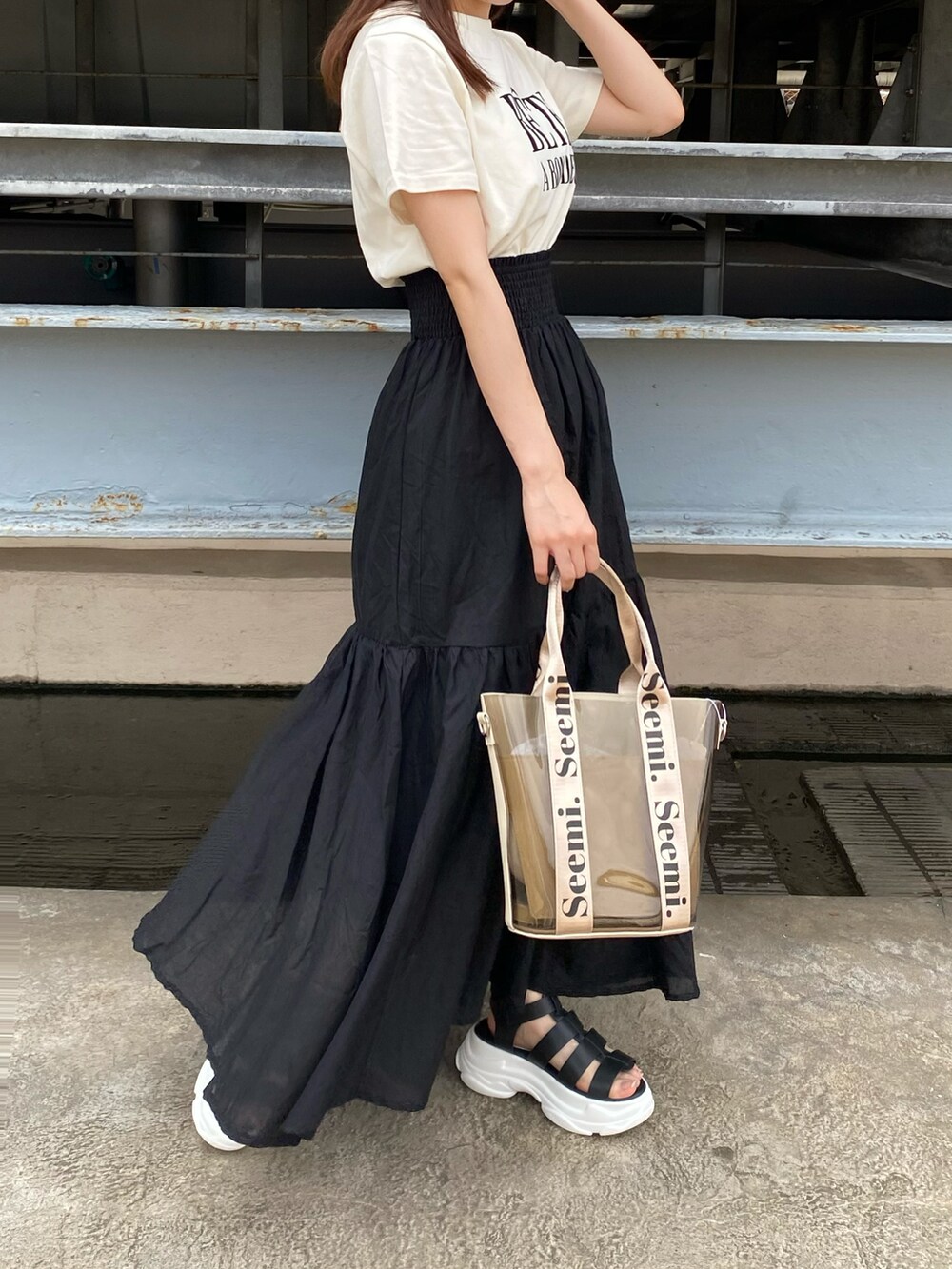 ブラック系のサンダル、ホワイト系のTシャツ/カットソー、ブラック系のスカートを着用したレディースの夏コーディネートの3枚目の写真
