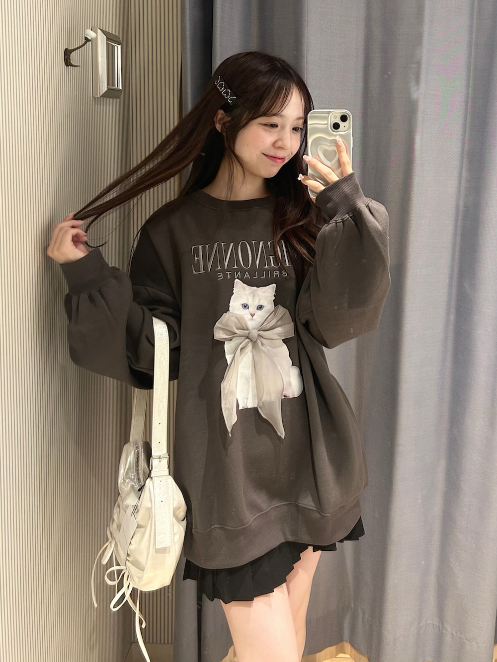 ホワイト系のショルダーバッグ、ブラック系のTシャツ/カットソー、ブラック系のスカートを着用したレディースの秋コーディネートの3枚目の写真