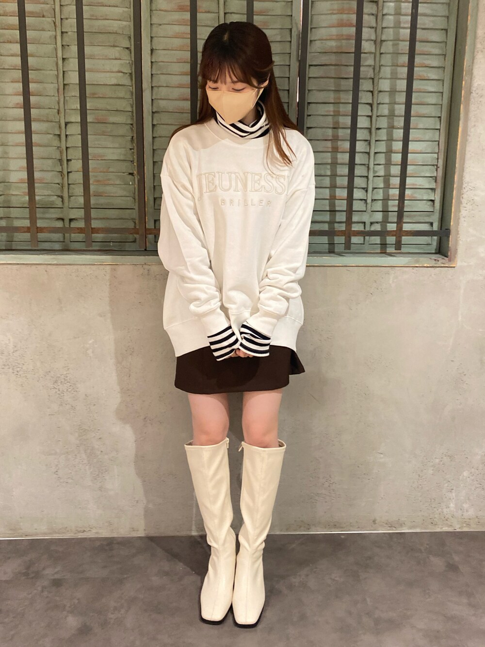ホワイト系のスウェット、ブラック系のTシャツ/カットソー、ブラウン系のスカートを着用したレディースの秋コーディネートの2枚目の写真