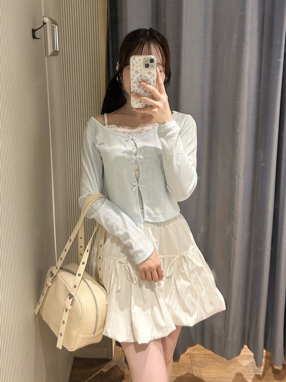 ホワイト系のショルダーバッグ、ホワイト系のスカート、ブルー系のTシャツ/カットソーを着用したレディースの春コーディネートの5枚目の写真