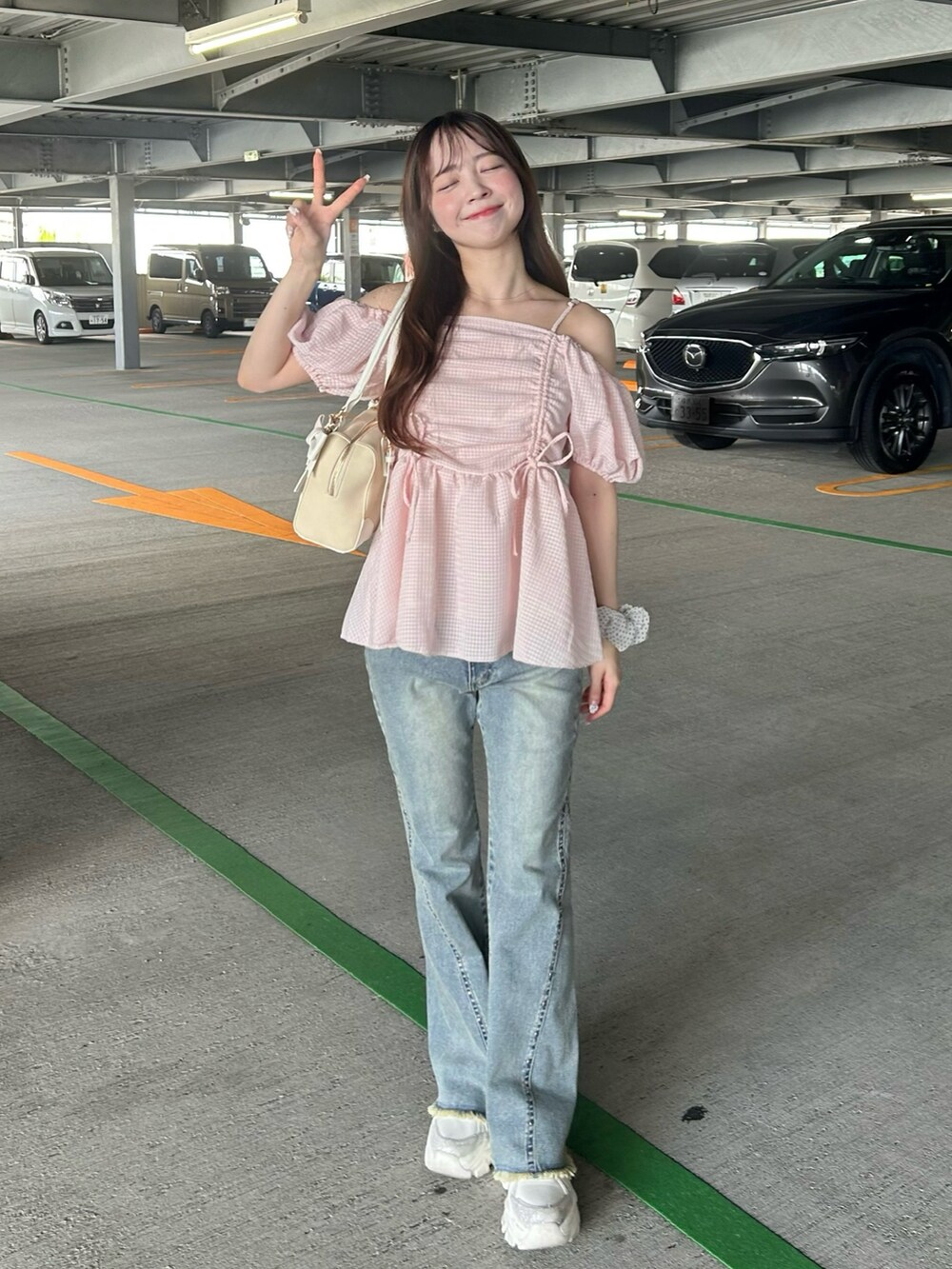 ピンク系のシャツ/ブラウス、ブルー系のデニムパンツ、ホワイト系のスニーカーを着用したレディースの夏コーディネートの4枚目の写真