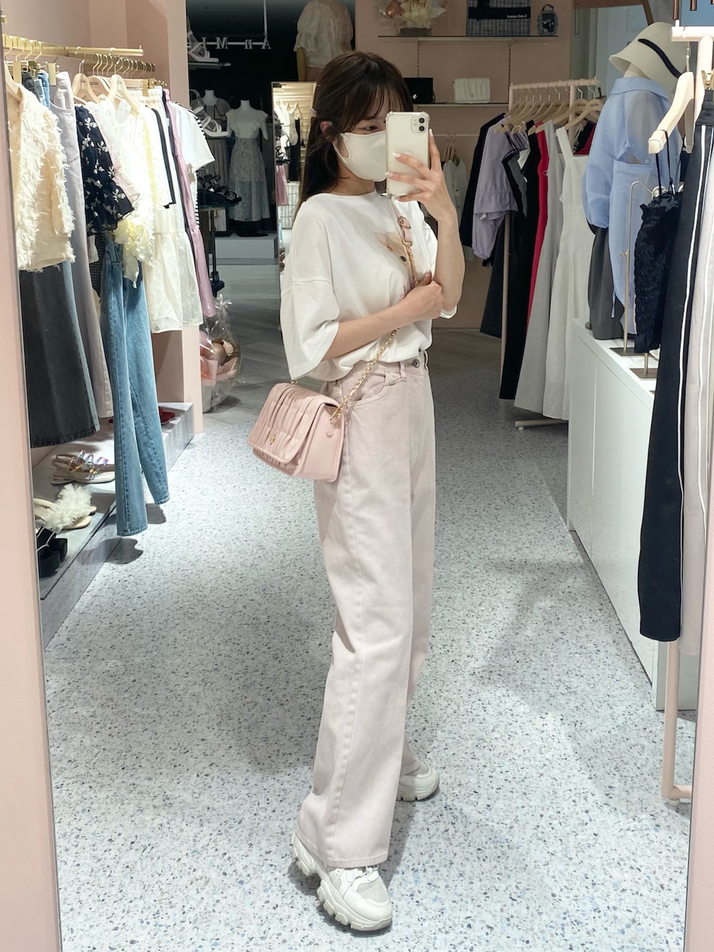 ホワイト系のスニーカー、ピンク系のデニムパンツ、ピンク系のショルダーバッグを着用したレディースの夏コーディネートの2枚目の写真