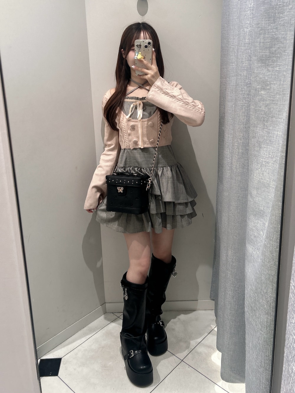 グレー系のワンピース、ブラック系のショルダーバッグ、ブラック系のブーツを着用したレディースの秋コーディネートの4枚目の写真