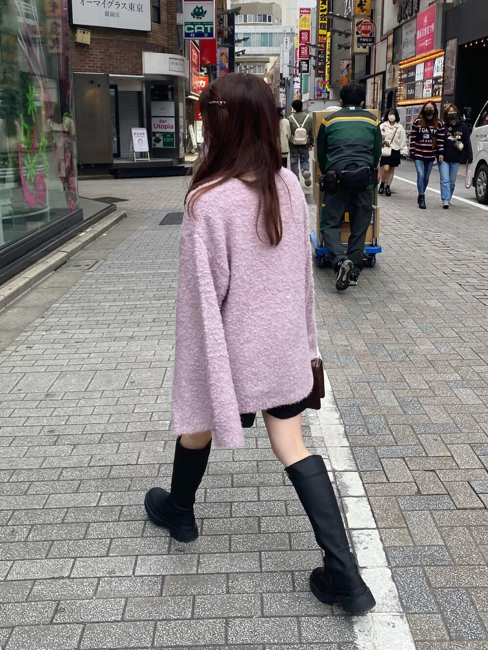 ピンク系のニット/セーター、ブラック系のその他パンツ、ブラック系のブーツを着用したレディースの秋コーディネートの3枚目の写真