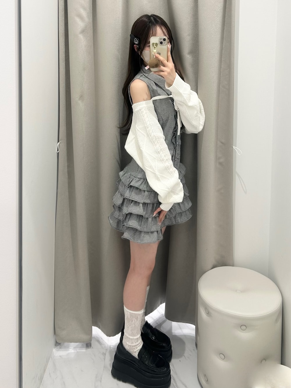 ブラック系のワンピース、ホワイト系のカーディガン/ボレロ、ブラック系のローファーを着用したレディースの春コーディネートの2枚目の写真