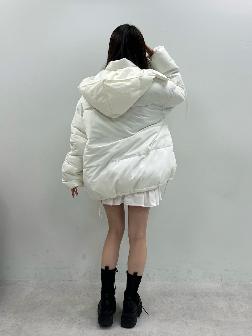 ホワイト系のダウンジャケット/コート、ホワイト系のスカート、ブラウン系のTシャツ/カットソーを着用したレディースの冬コーディネートの5枚目の写真