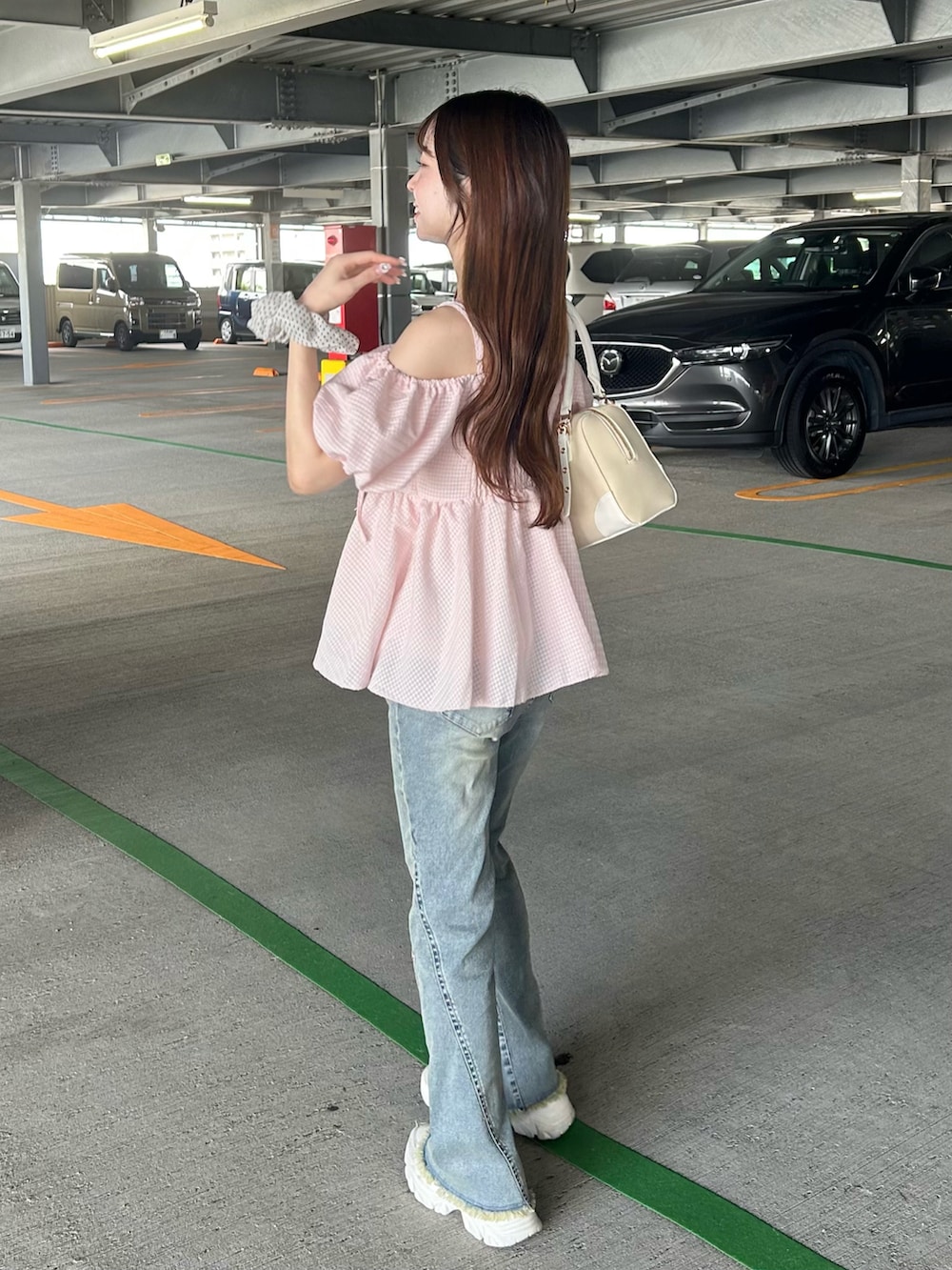 ピンク系のシャツ/ブラウス、ブルー系のデニムパンツ、ホワイト系のスニーカーを着用したレディースの夏コーディネートの3枚目の写真