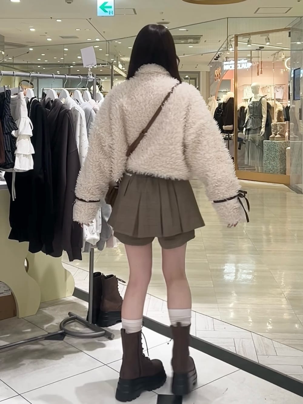 ブラウン系のブーツ、ブラウン系のショルダーバッグ、ブラウン系のスカートを着用したレディースの秋コーディネートの9枚目の写真