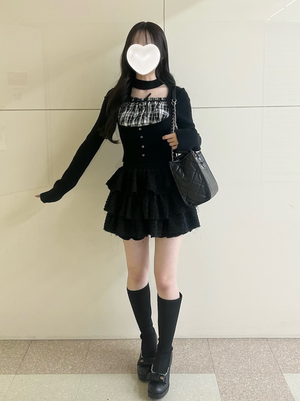 ブラック系のスカート、ブラック系のトートバッグ、ブラック系のブーツを着用したレディースの春コーディネートの3枚目の写真