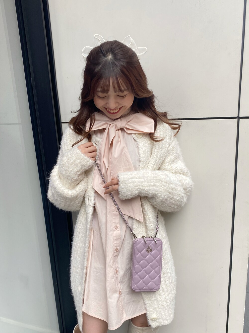 ホワイト系のブーツ、ピンク系のシャツ/ブラウス、ホワイト系のカーディガン/ボレロを着用したレディースの冬コーディネートの5枚目の写真