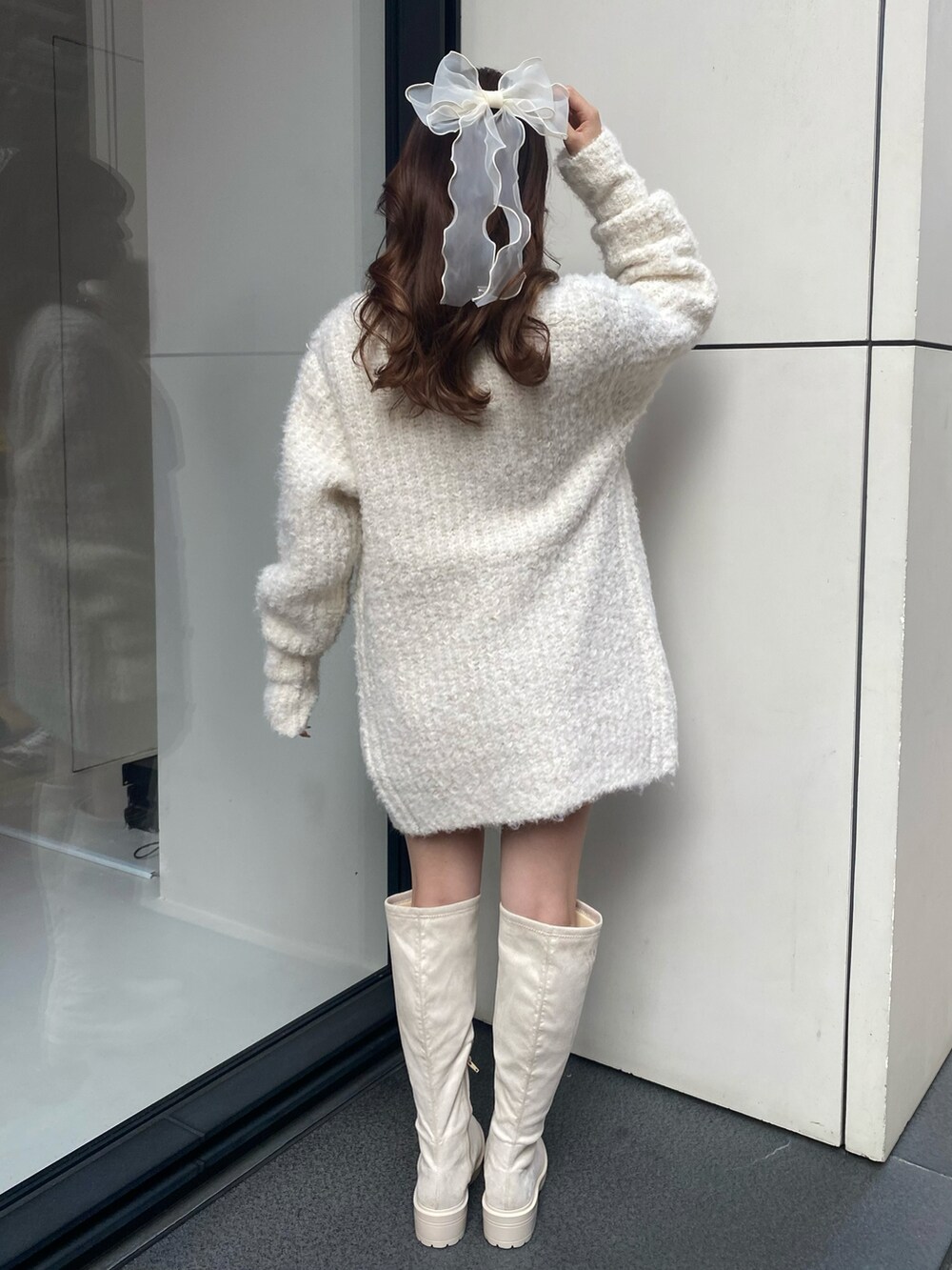 ホワイト系のブーツ、ピンク系のシャツ/ブラウス、ホワイト系のカーディガン/ボレロを着用したレディースの冬コーディネートの3枚目の写真