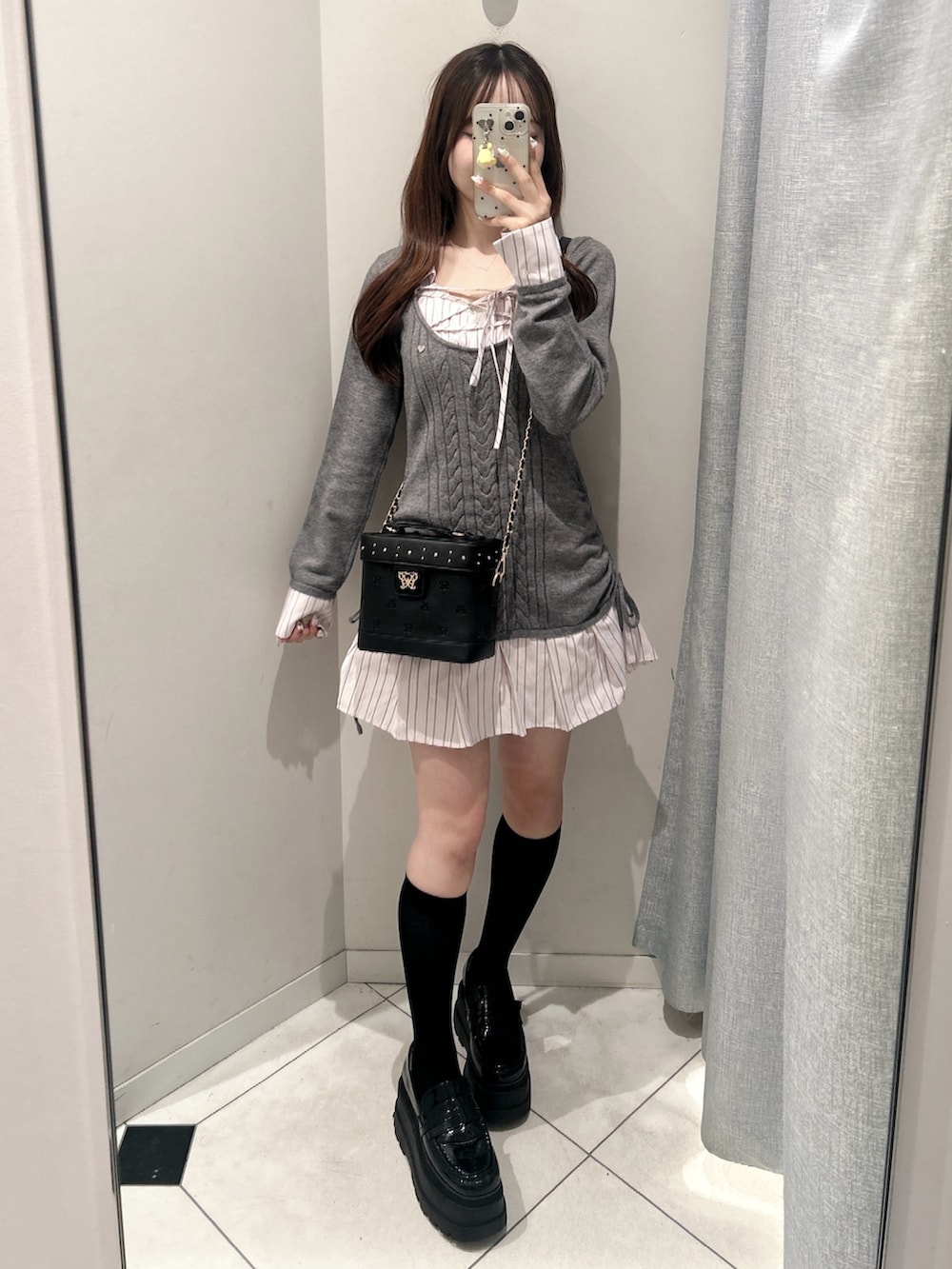 グレー系のワンピース、ブラック系のショルダーバッグを着用したレディースの秋コーディネートの3枚目の写真