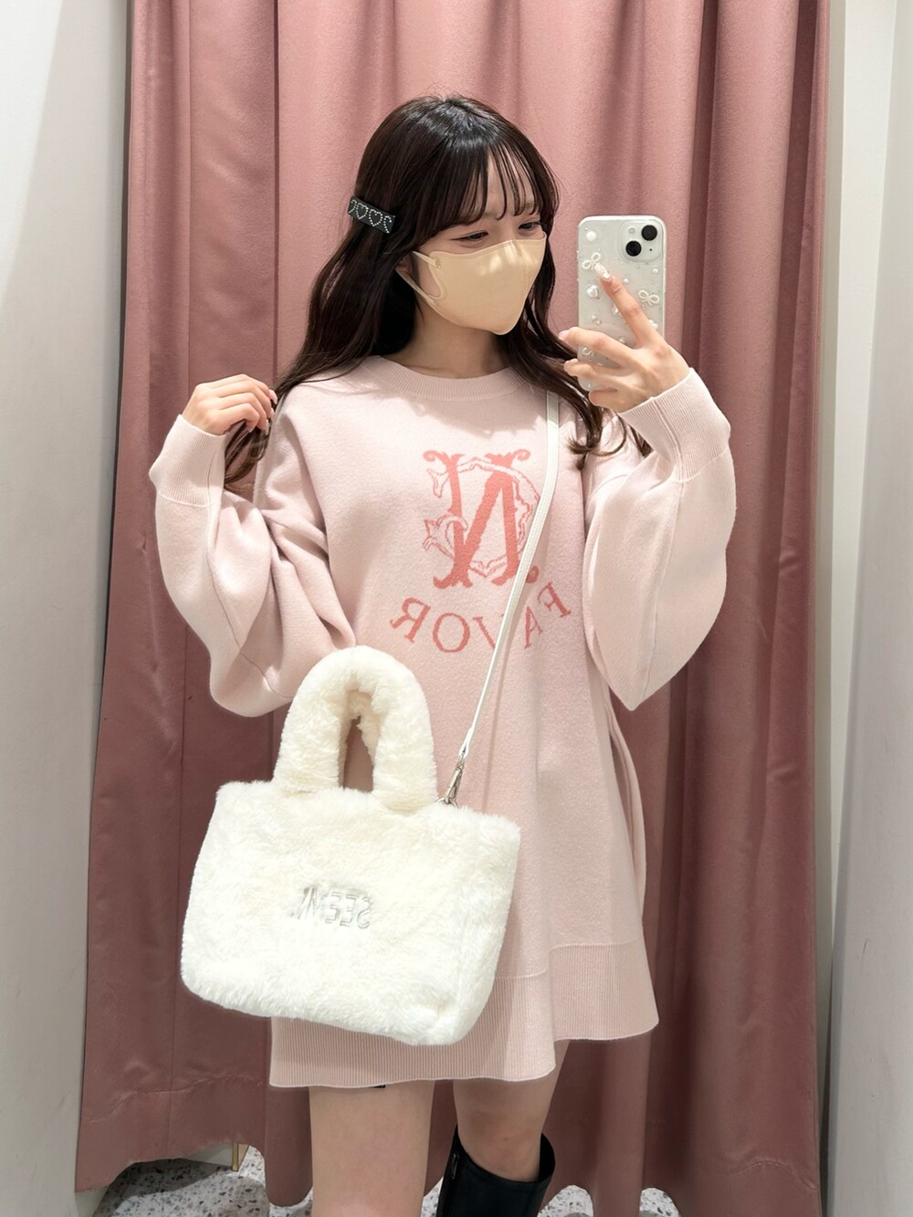 ピンク系のニット/セーター、ホワイト系のトートバッグ、ブラック系のブーツを着用したレディースの冬コーディネートの4枚目の写真