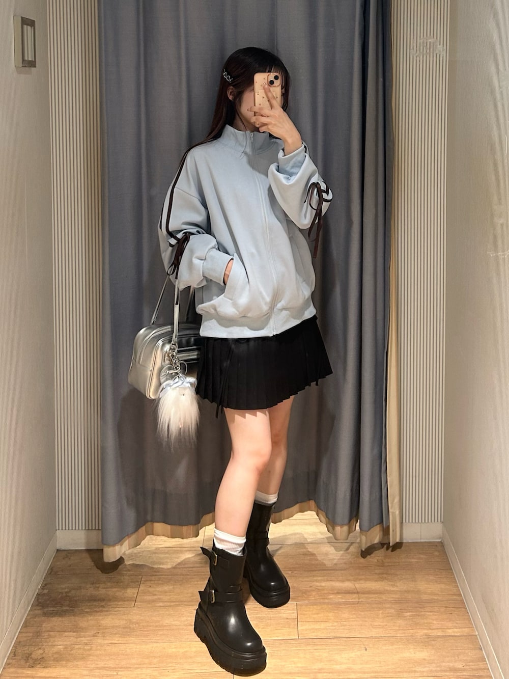 ブラック系のスカート、ブルー系のジャージ、ブラック系のブーツを着用したレディースの秋コーディネートの2枚目の写真